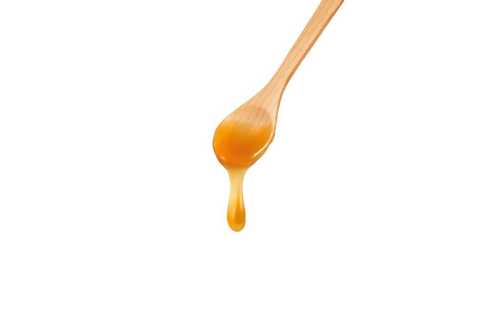 Wooden spoon with Manuka honey dripping from it.